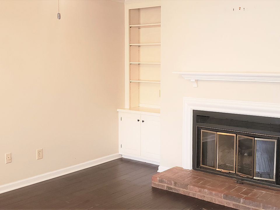 Living room with builtin bookcase and storage and a fireplace.