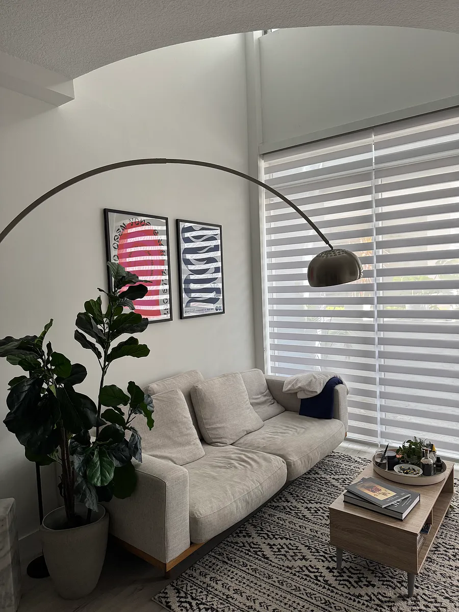Living Area - Sun-drenched living room with expansive windows, creating a warm and inviting atmosphere. Perfect for relaxing or entertaining in a bright, airy environment. Zebra shades provide added privacy without compromising natural light exposure. - 3339 Virginia St #129