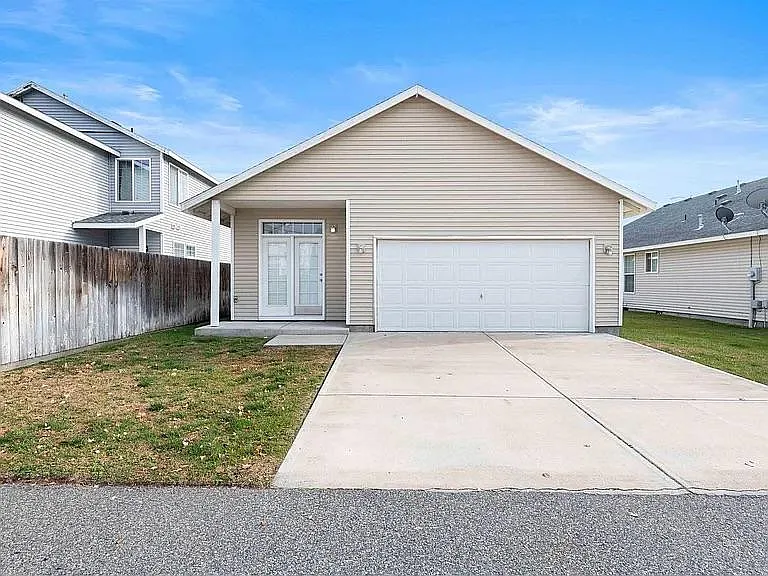 Back of house. Double garage, 3rd bedroom with French doors and small yard