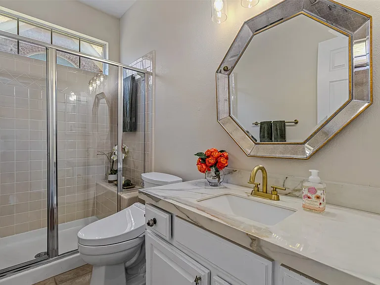 Bathroom featuring a glass-enclosed shower with tiled walls and a transom window