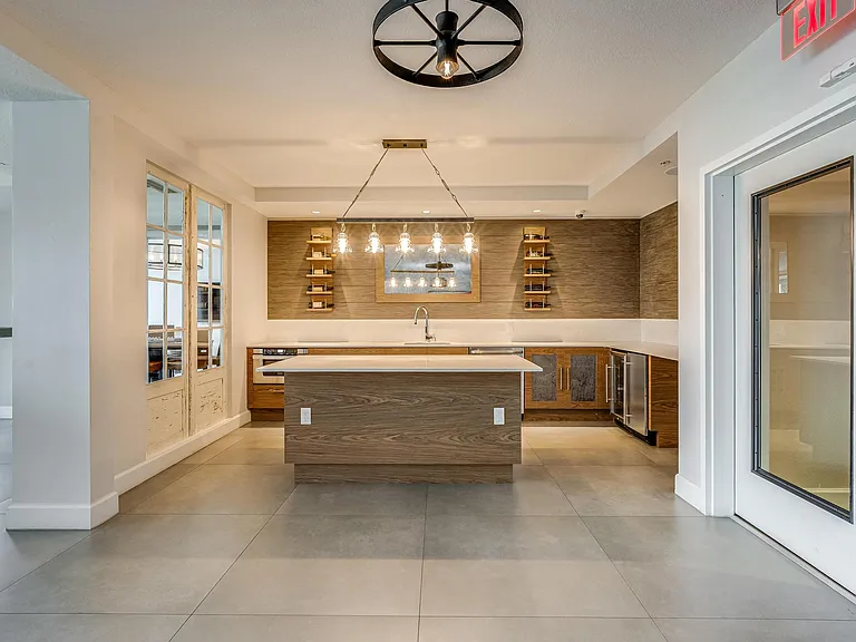 Open Kitchenette with Wall Shelving, Island Counter, and Wine Fridge