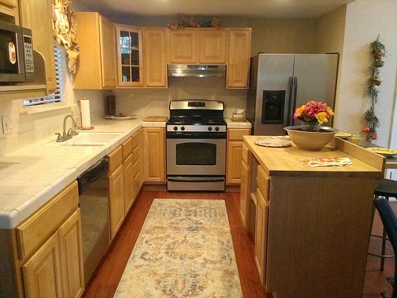 NEWER MAPLE KITCHEN W/ STAINLESS APPLIANCES & PERGO FLOORS