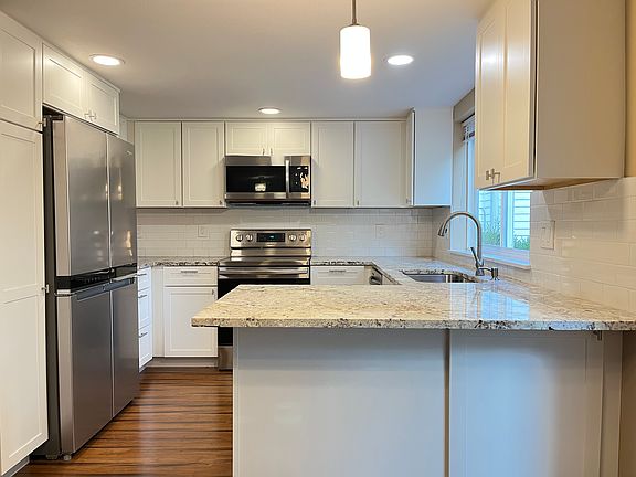 Remodeled kitchen with quartz countertops, stainless steel appliances