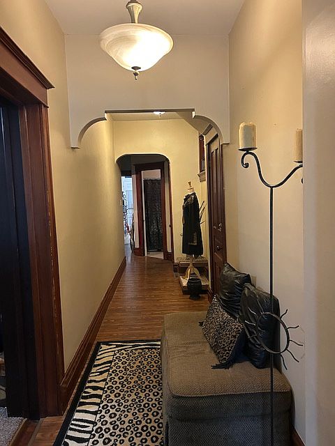 Arched hallway with pocket door leading to kitchen, bathroom, and bedroom.