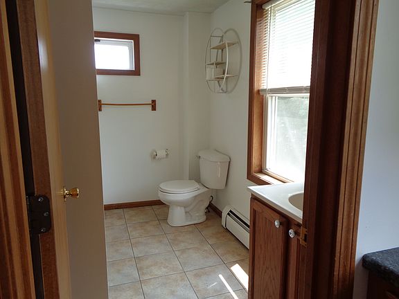 Sunny bathroom with ceramic tile flooring. Freshly painted last year. No additional wall mounted shelves/rods/hooks allowed.