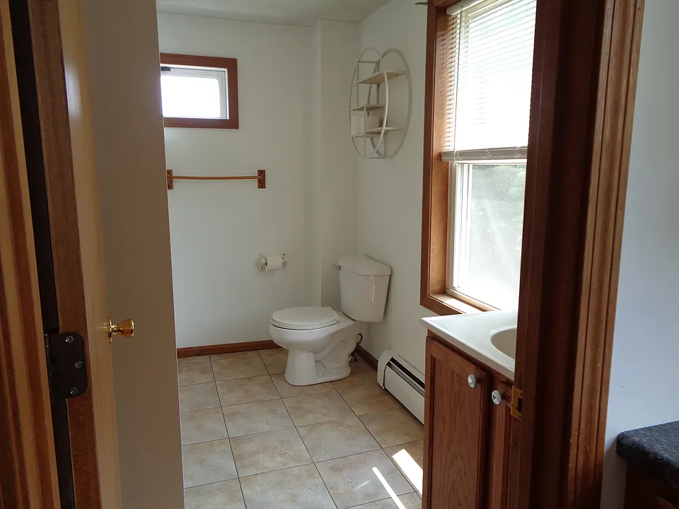 Sunny bathroom with ceramic tile flooring. Freshly painted last year. No additional wall mounted shelves/rods/hooks allowed.