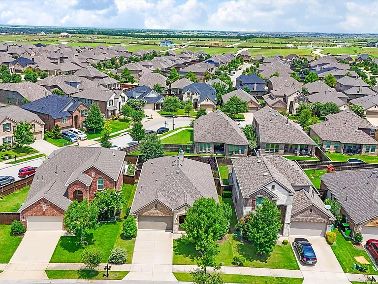 Residential development featuring a variety of architectural styles, manicured lawns, and mature trees