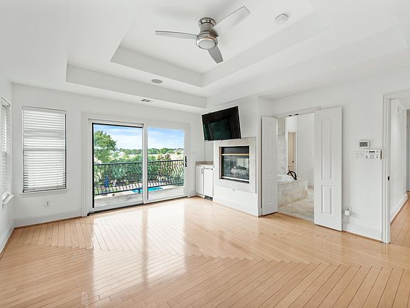 Primary bedroom with fireplace, television, and small refrigerator