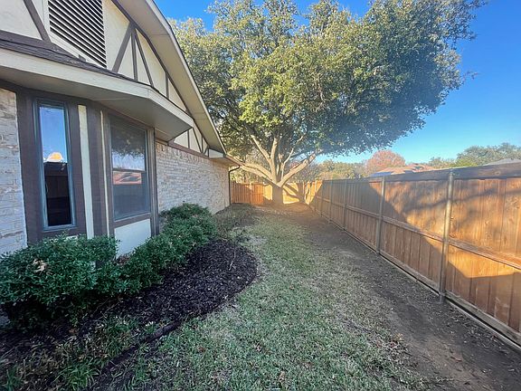 Fenced side yard with large shade tree