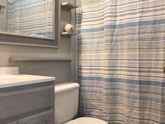 Updated bath with large mirror, custom shelves, new lighting and new fixtures.