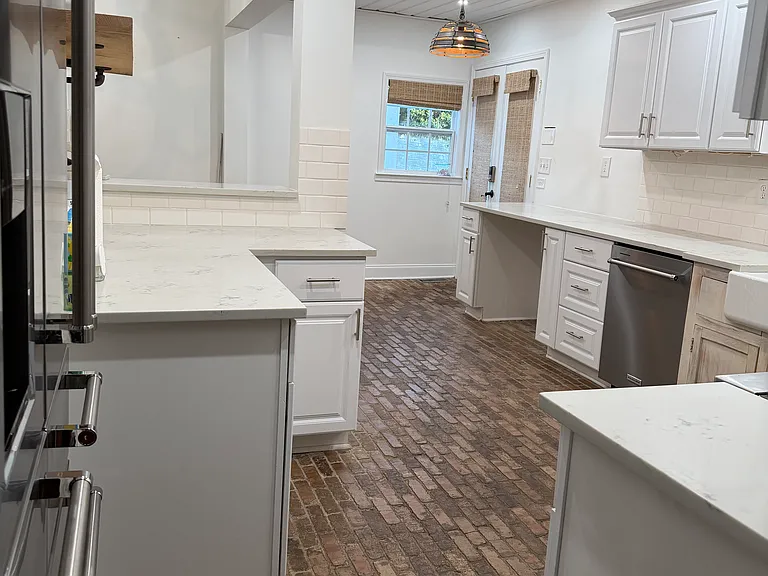 Spacious kitchen with quartz countertops and brick floors