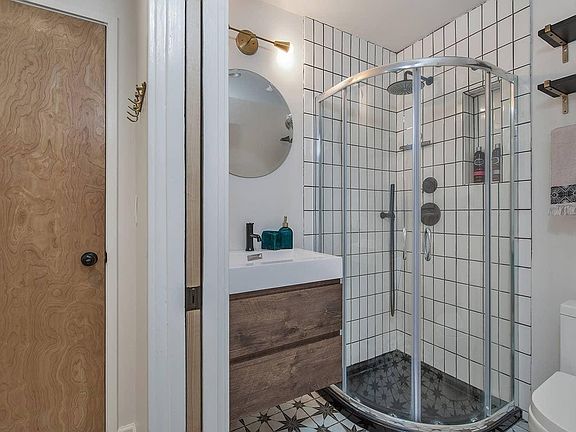 Cozy, beautifully appointed bathroom with ample storage and standing shower.