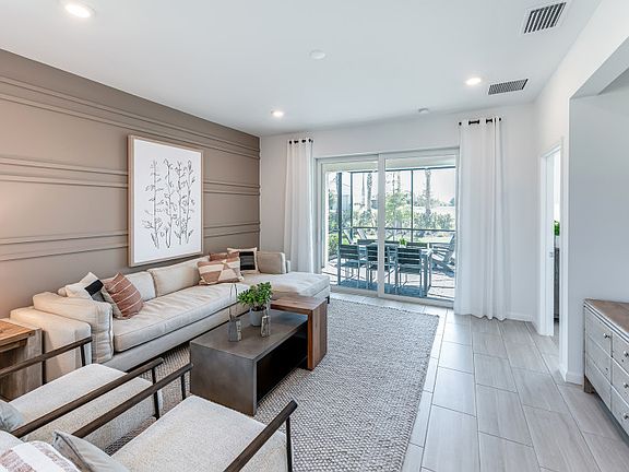 Open gathering room with sliding glass doors to the covered lanai