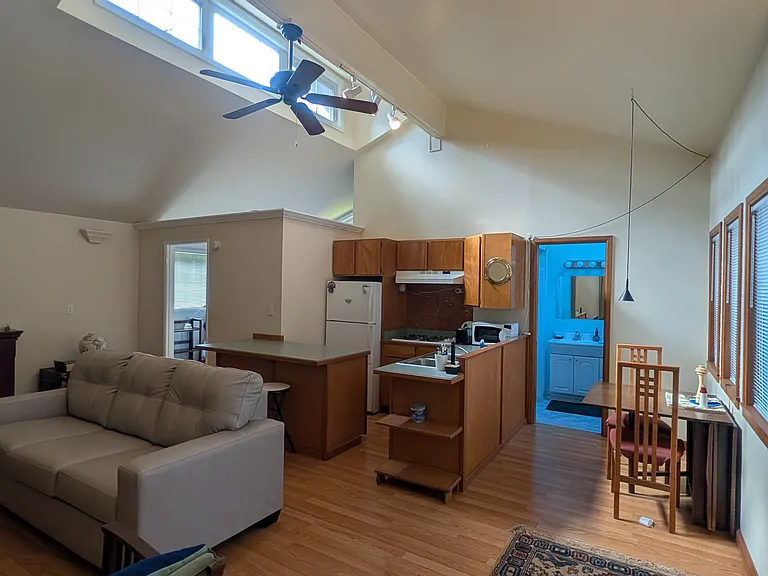 View from living area of full kitchen with loads of cabinet space and breakfast nook with table that folds out to accommodate more guests