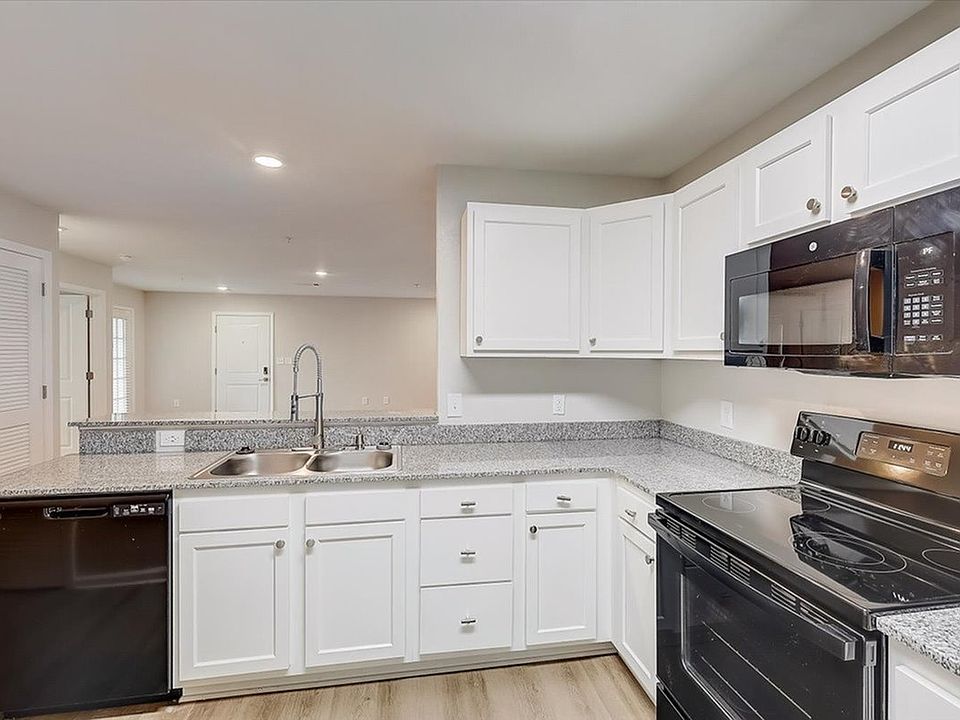 Upgrade your cooking experience with granite countertops, sleek black appliances, and white cabinetry at The Preserve Murfreesboro.