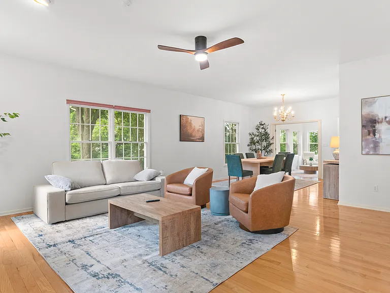 Inviting main living room with a cozy fireplace, comfortable furnishings, and large windows.