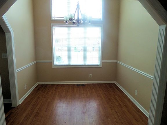 Lovely dining room with vaulted ceiling and wainscoting.
