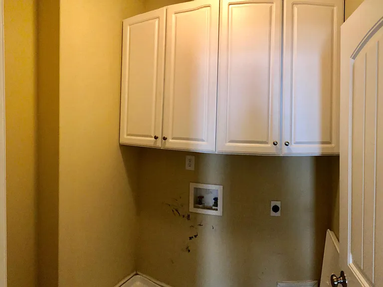 Laundry room provides cabinets and storage area on side