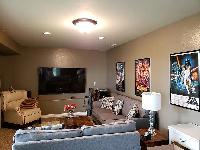 Downstairs home theater room is large and has huge windows but with blackout curtains for movie time.