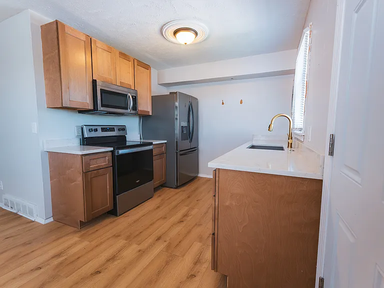 Newly designed kitchen with new cabinets, countertops, sink, hardware, and flooring