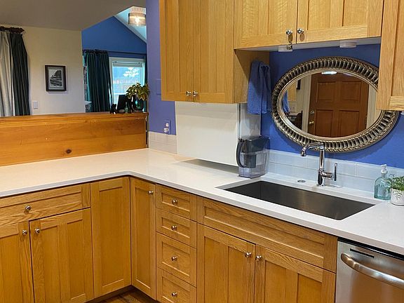 Oversized hand-forged sink and Kohler faucet with wedgewood cabinets and quartz countertops.