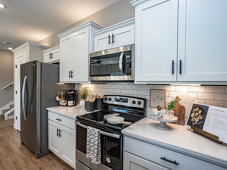 Kitchen with stainless steel appliances, breakfast bar, industrial sink and quartz countertops
