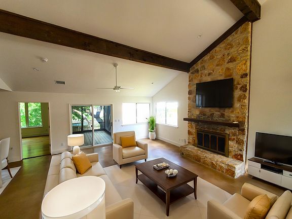 Living Room with Fireplace - View of Primary Bedroom & Screened Patio - Virtually Staged