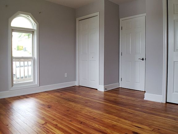 Bedroom off living room with 2 closets, lots of character with original wood floors, arched window
