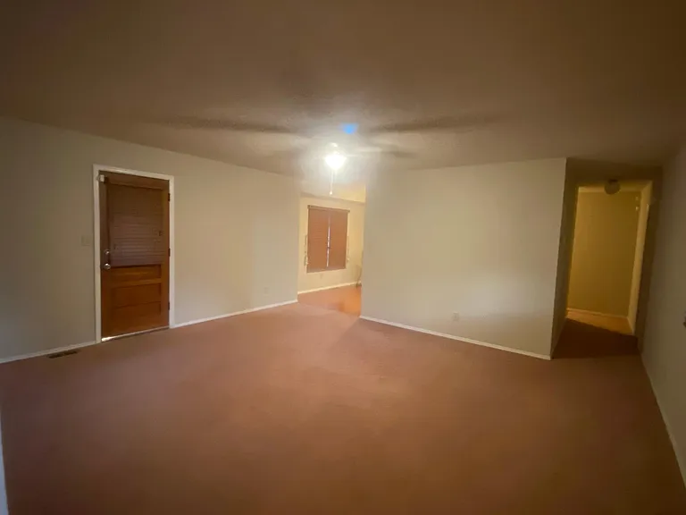 Living a room showing showing Rear Door, Dining Area and Hallway to Master Bedroom