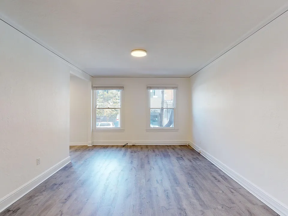Sunlit room with a wood-like flooring and windows