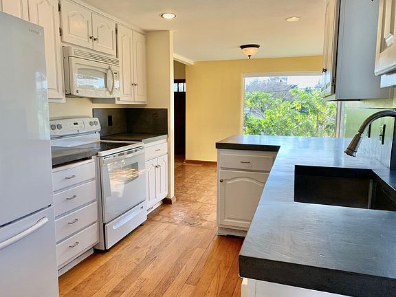Kitchen opens onto dining room and living room at the front of the house. Lots of storage cabinets and adjacent pantry closet.