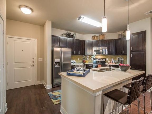 Luxurious kitchen, stainless steel appliances, stunning large islands and faux wood flooring.