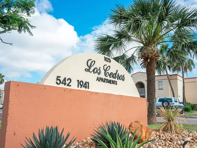 Community monument sign welcoming residents to Los Cedros Apartments in Brownsville, TX.