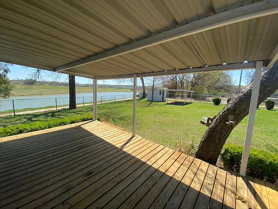 Deck off of the master bedroom - large backyard with expansive views of the lake. Storage shed and covered awning for tools, lawn mower etc.