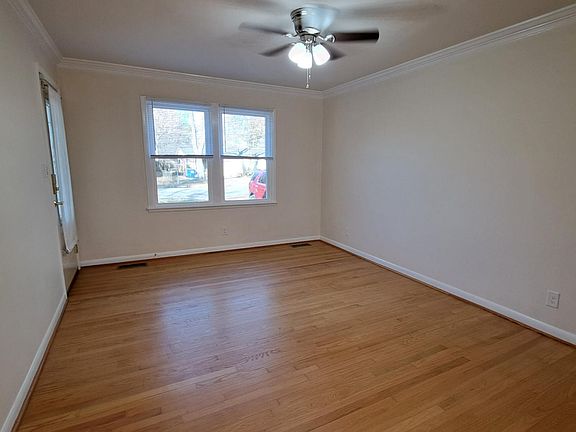 Living room with new ceiling fan/light, new windows, new blinds, and refinished hardwoods.