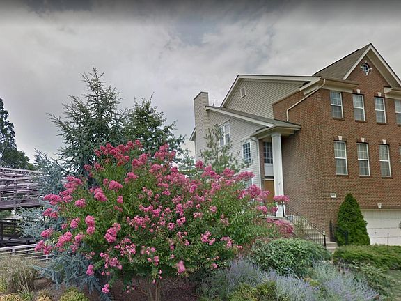 Brick house front, corner house, backs to woods, water and open space, with a trail in the back.