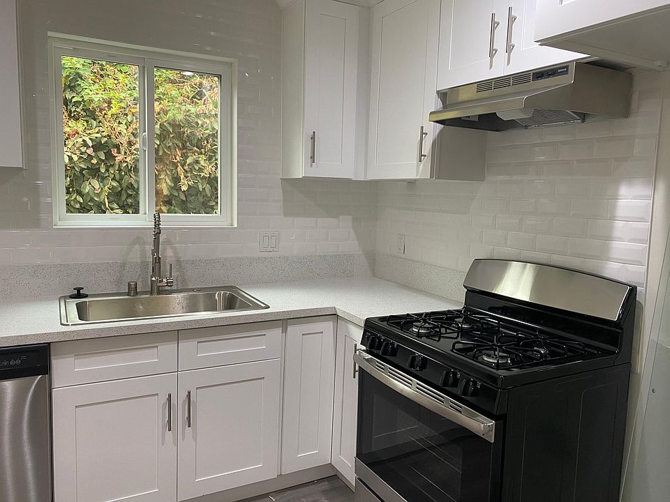 Beautiful fully functioning kitchen with stainless steel appliances including dishwasher, garbage disposer, gas stove, oven. The kitchen has so many designer touches including quartz counter tops, subway tile backsplash, and shaker style cabinets with sl