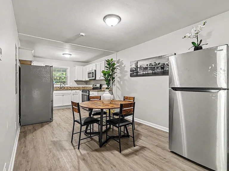 Open kitchen with stainless appliances, ample cabinet space, and an eat-in dining area with room for four.