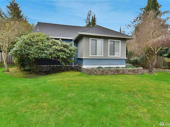 Charming living room with glass pane door leads to quaint front entry room. 