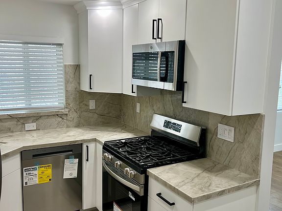 Upgraded itchen with Natural Quartz Counters, Stainless Steel Appliances and Custom Cabinets