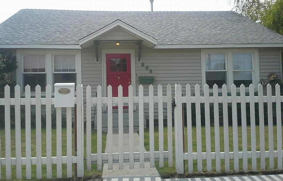 View of house from E 1st St, including window boxes, picket 