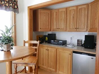 Additional oak cabinets with a wet bar adjacent to the dining area