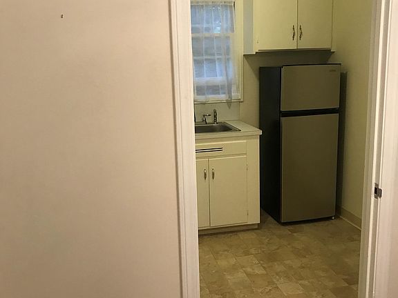 Kitchen with Stainless refrigerator. Room for small table.