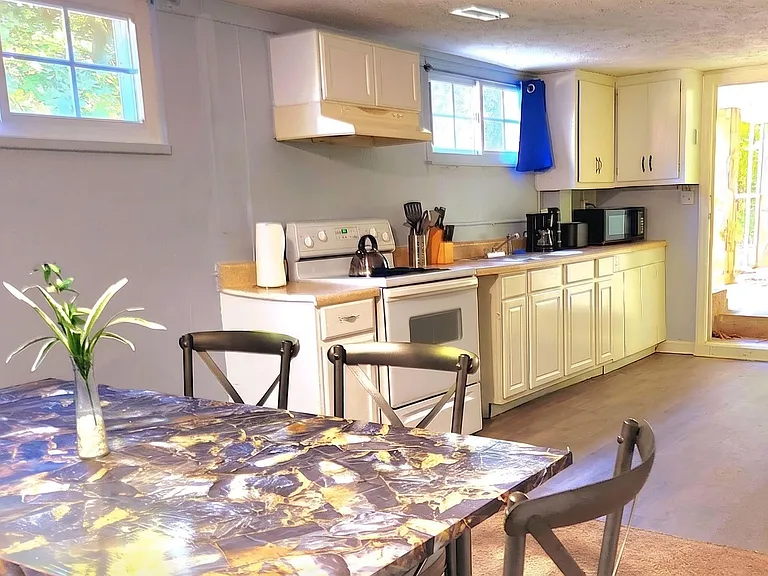 Eat-in kitchen with ample cabinet storage, full appliance set, and convenient exterior access for easy daily living.
