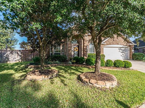 Front elevation features mature oaks and gorgeous landscaping.