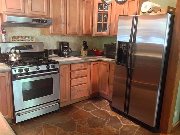 Stone flooring in the kitchen. Microwave, refrigerator and gas range/oven. Coffee maker, coffee grinder, blender, mixer, all necessary cookware and flatware.