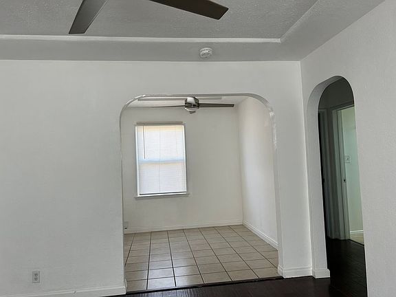 Dining room with tile floor and remote controlled ceiling fan. Archways add charm & character.