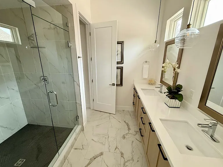 Master bathroom with his and hers sink, large walk in shower with bench, and separate toilet room