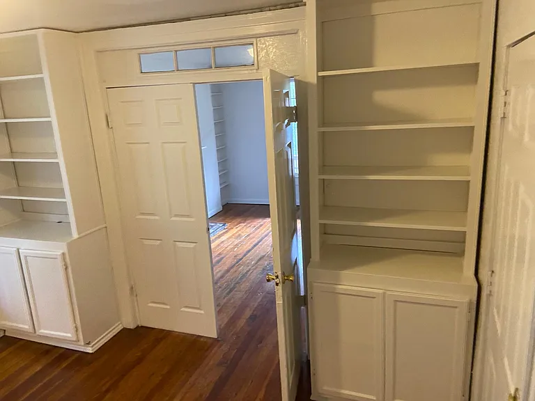Living room next to kitchen with built in cabinets adjoining kitchen and tv room