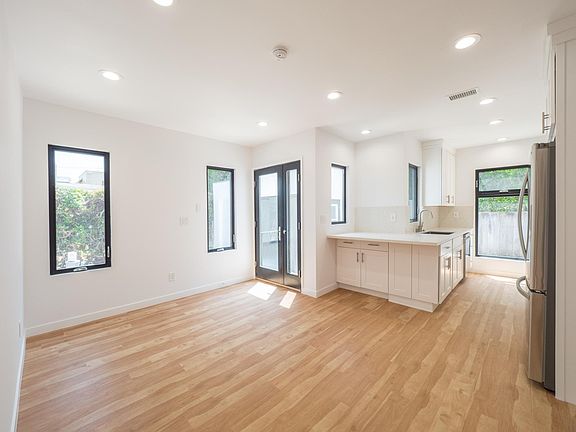 Entry into living area; kitchen with bar counter space; kitchen view to back garden